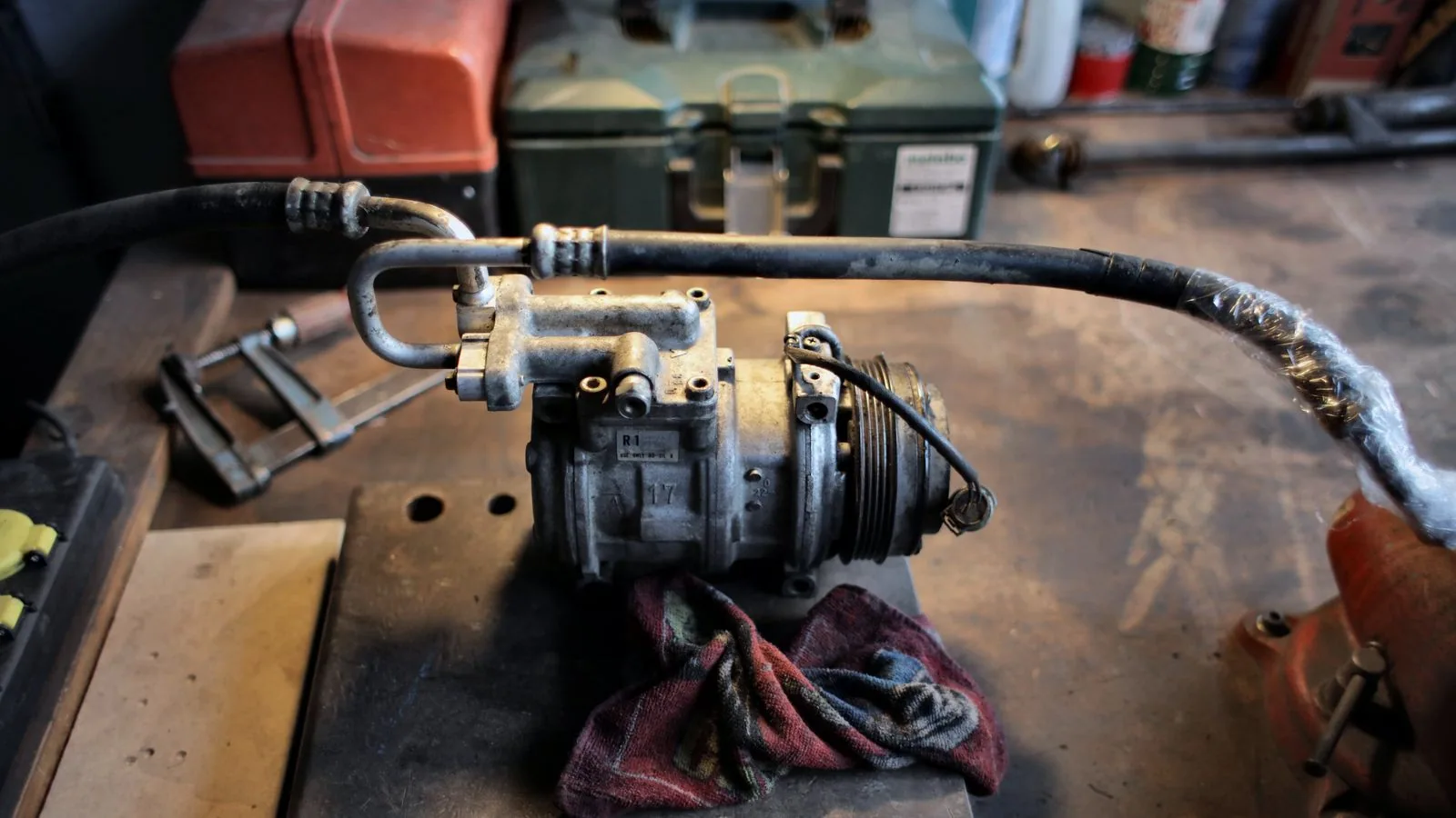 Photographie : un compresseur à cuve et son flexible d'air dans un garage de particulier