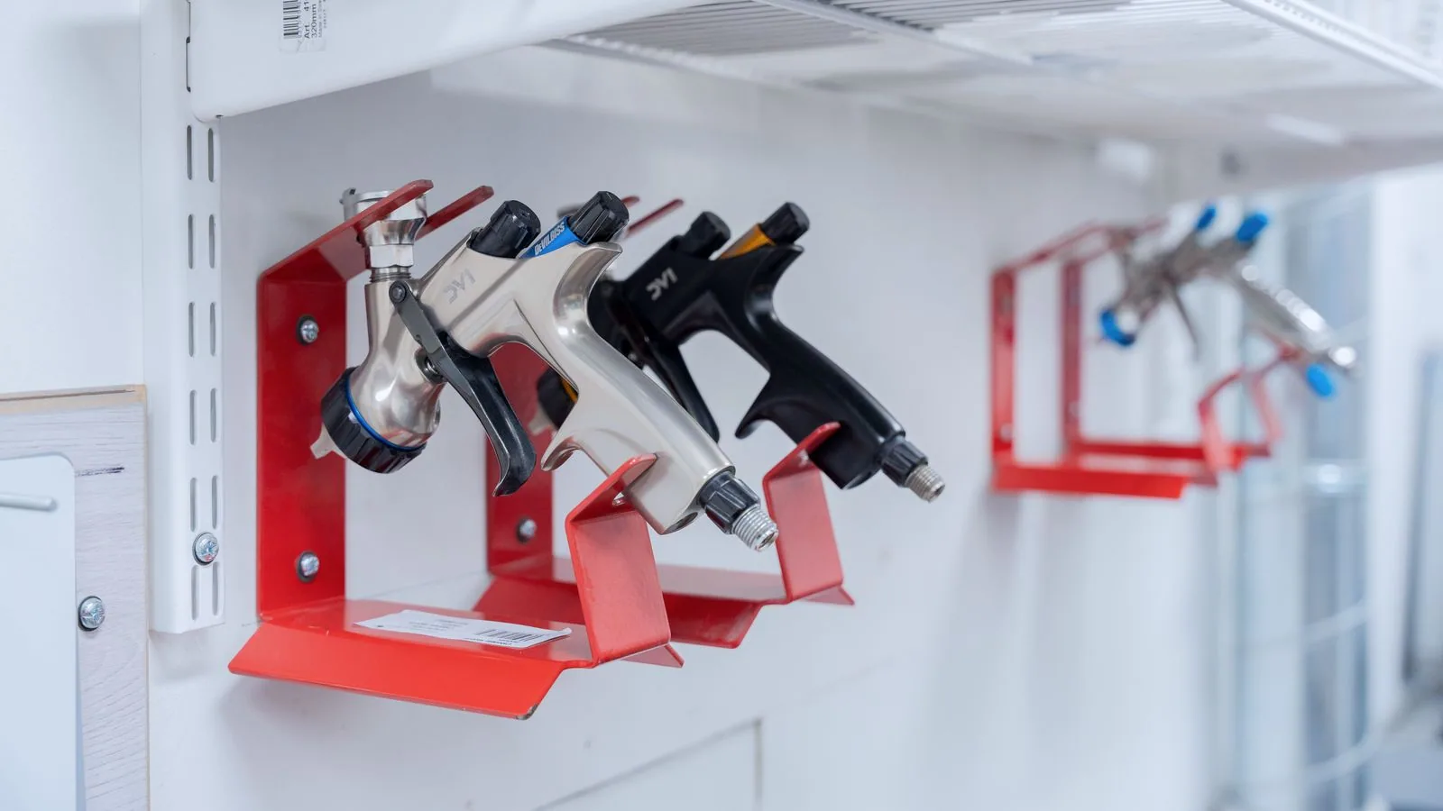 Photographie : des outils pneumatiques reliés à leur flexible d'air dans un garage