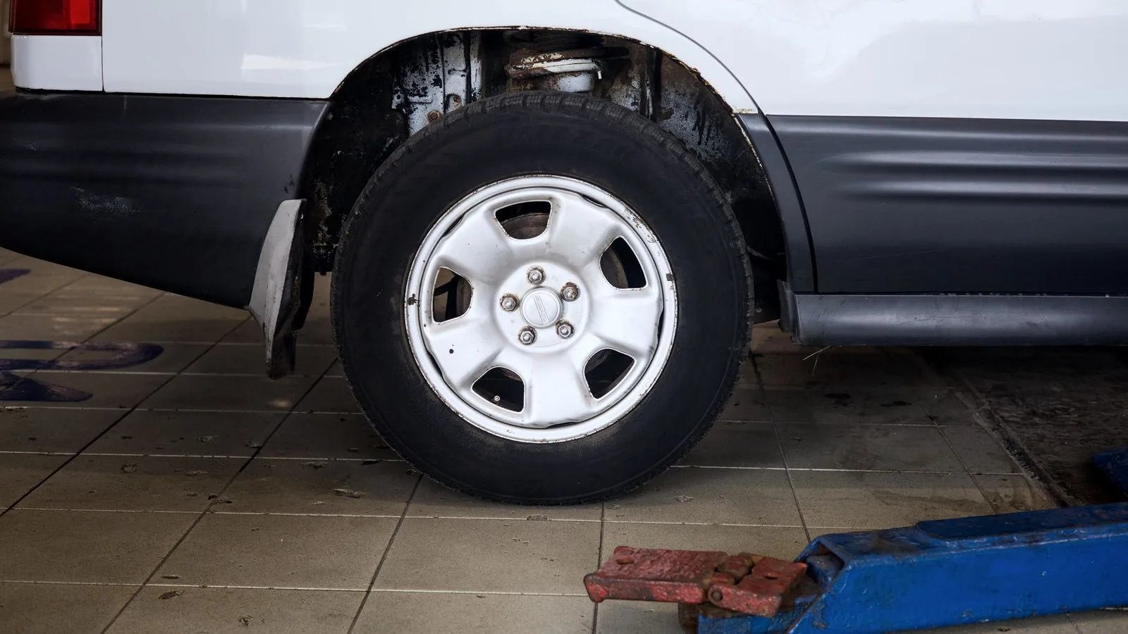Photographie : une voiture levée sur chandelles dans un garage