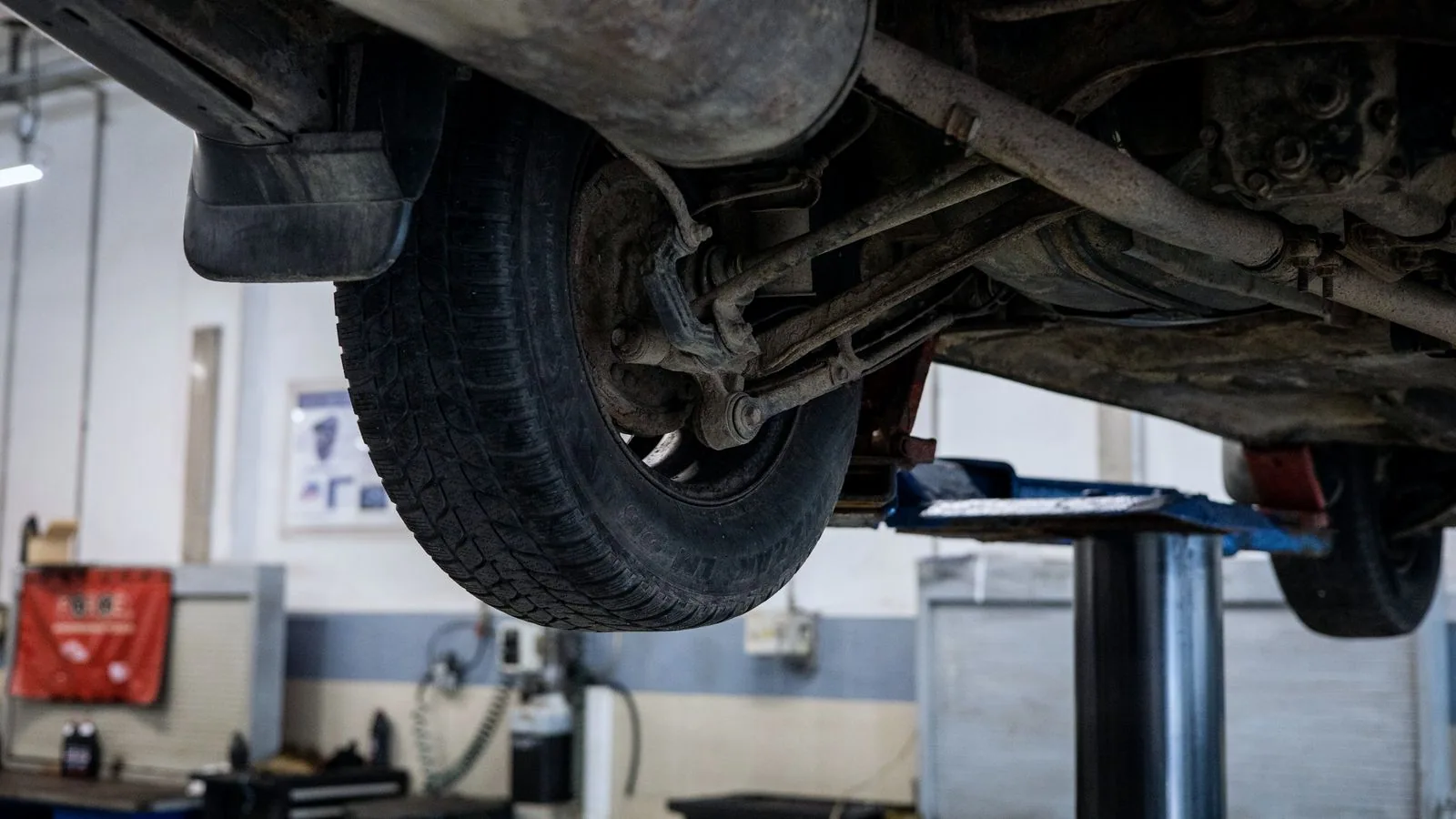 Photographie : l'avant d'une voiture monté sur une paire de rampes de levage, roues au sol